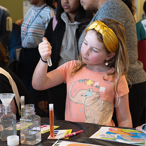 Child looking at a test tube