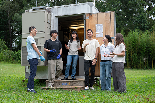 a group of people standing outside of a trailer with smiles on their faces