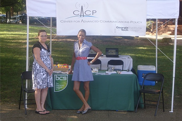 two females standing outside under a white tent