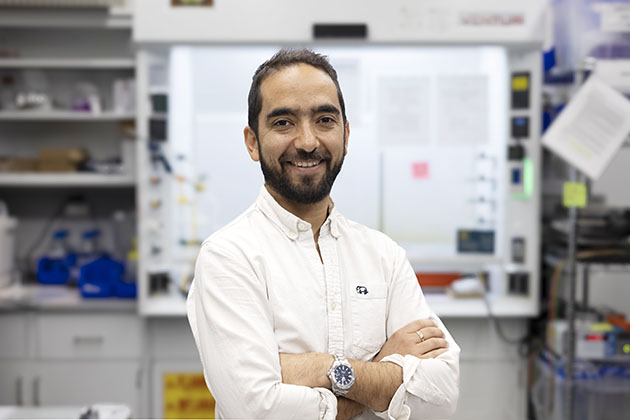 Juan-Pablo Correa-Baena in a white shirt standing with arms crossed in a Georgia Tech lab