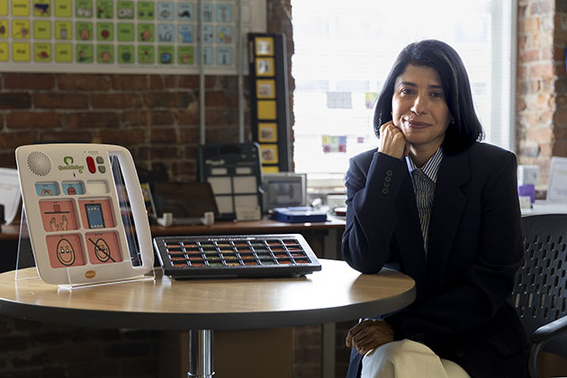 Woman sitting with a tablet assistive device with her on a table