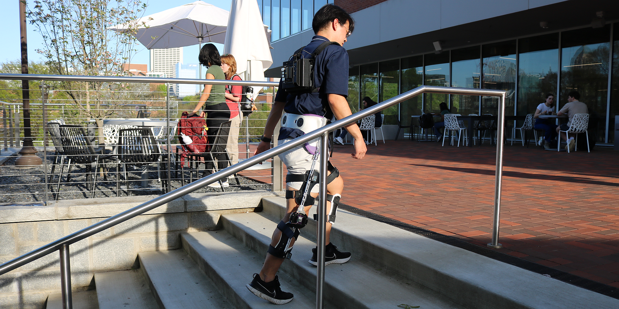 student walking on stairs using an exoskeleton