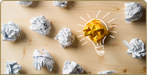 Stock image of light bulb amongst crumpled paper
