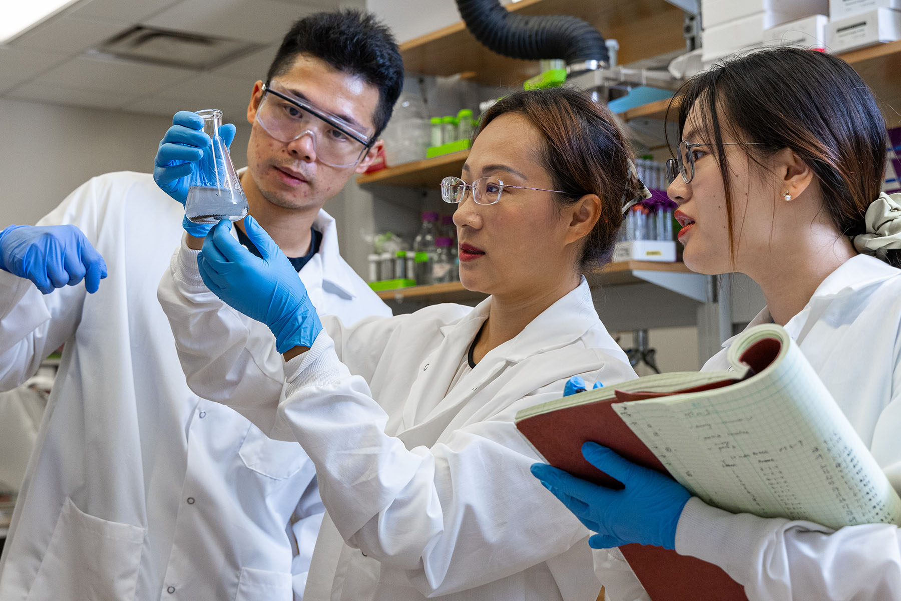 Tang, post-doctoral researcher Yinghao Wen, and Ph.D. student Hang Xu check out the reaction for recovering rare earth elements from combustion residue.