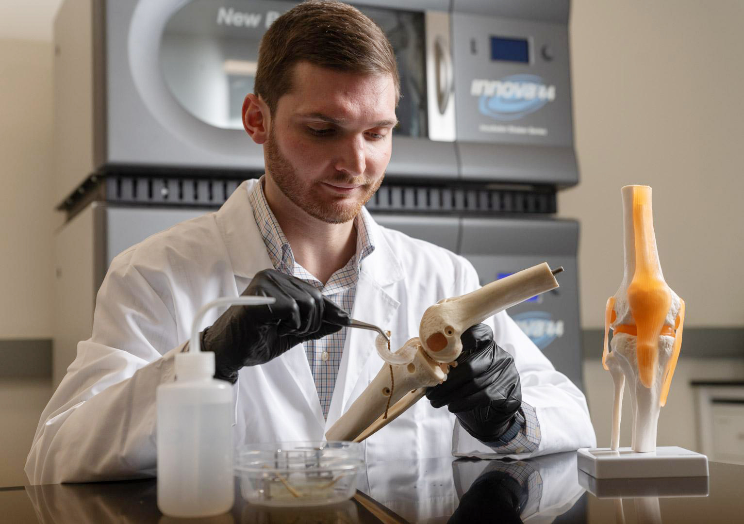 Jonathan Schwartz working on a meniscus implant on a knee model