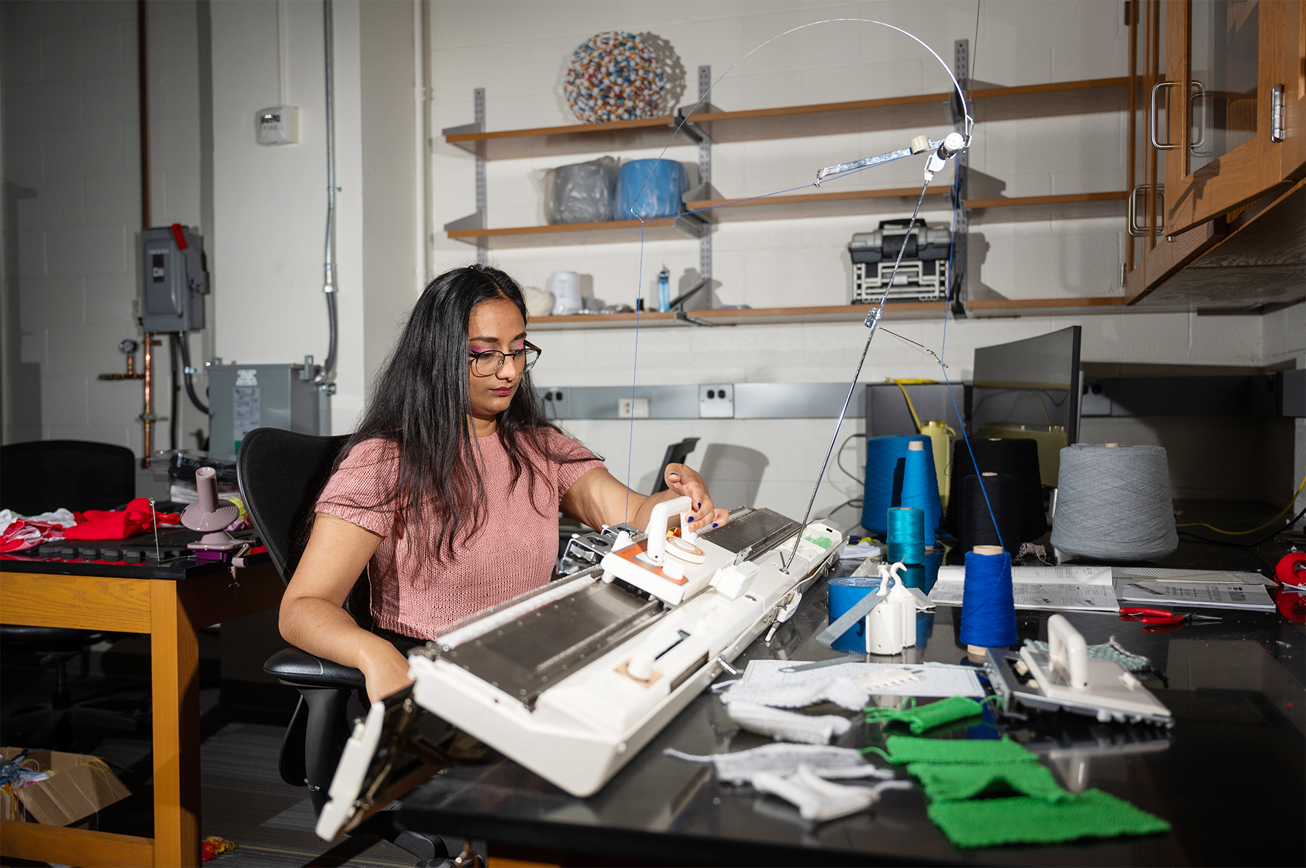 Krishma Singal operates a knitting machine in a research lab at Georgia Tech