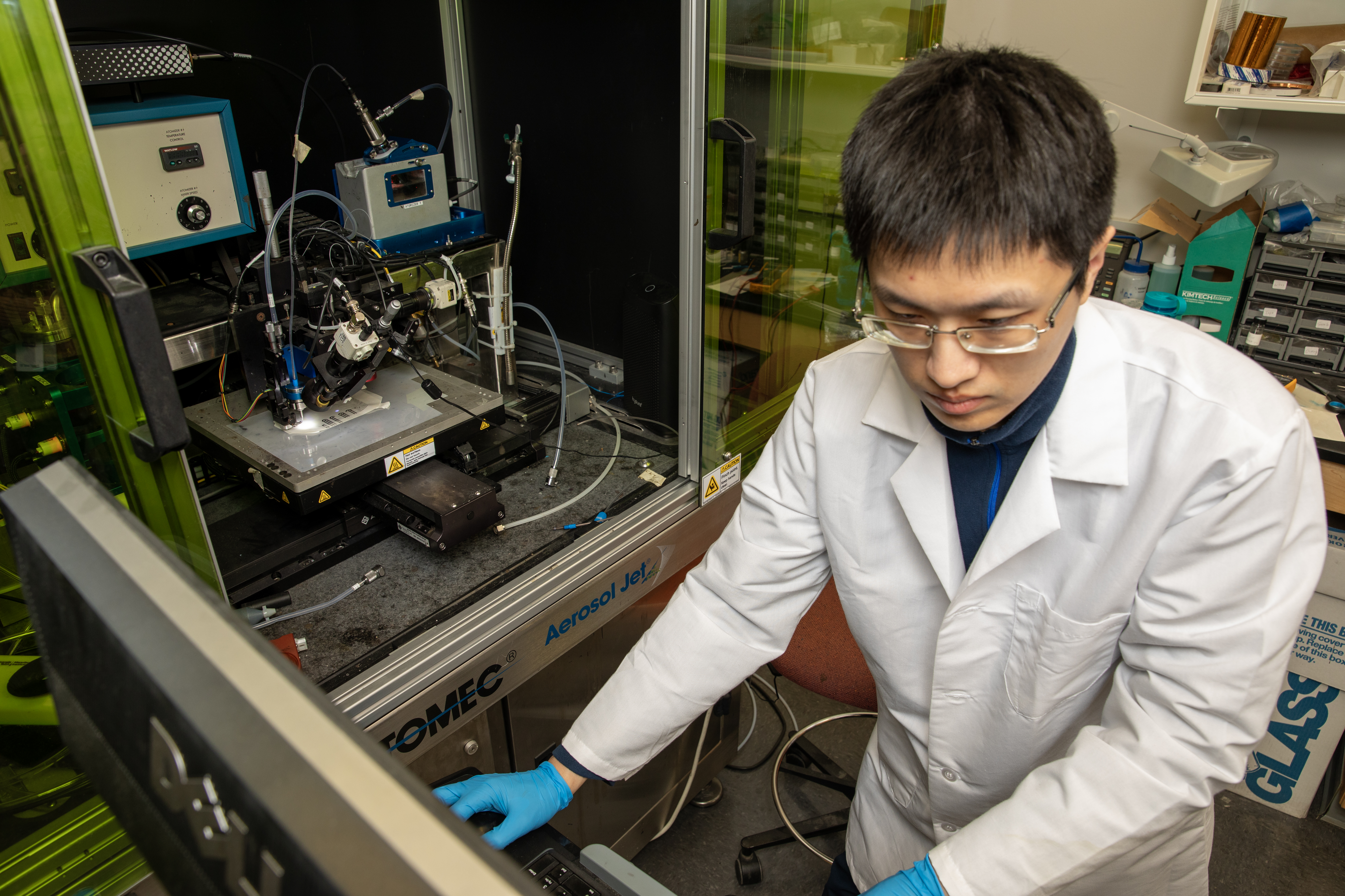 A photo of a Georgia Tech graduate student operating the Aerosol Jet® printer to fabricate the sensor. 