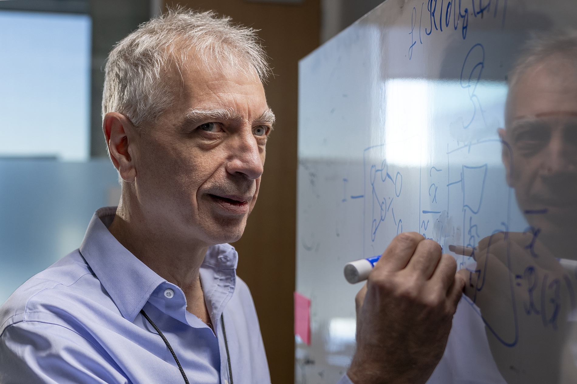 Pascal Van Hentenryck shown close up writing on a white board