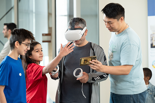 two student and two adults try out virtual reality glasses