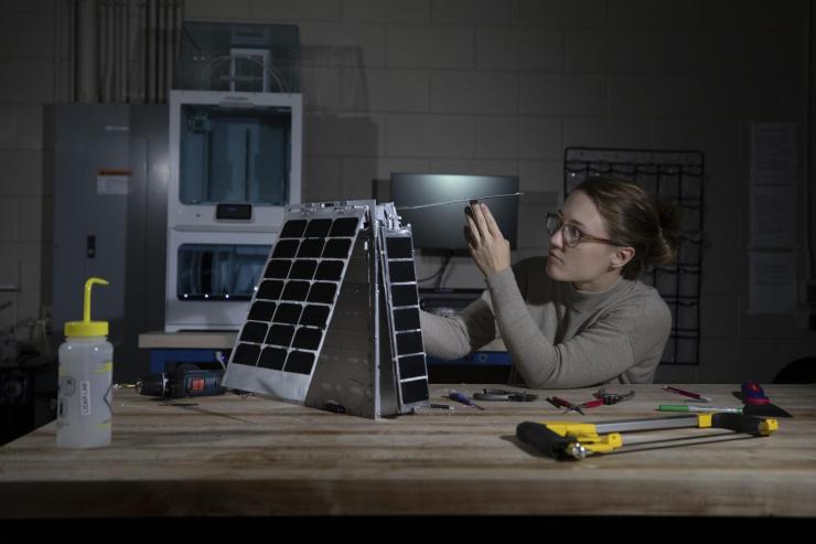 <p>Mary Kate Broadway adjusts the model's solar array. (photo: Sean McNeil)</p>
