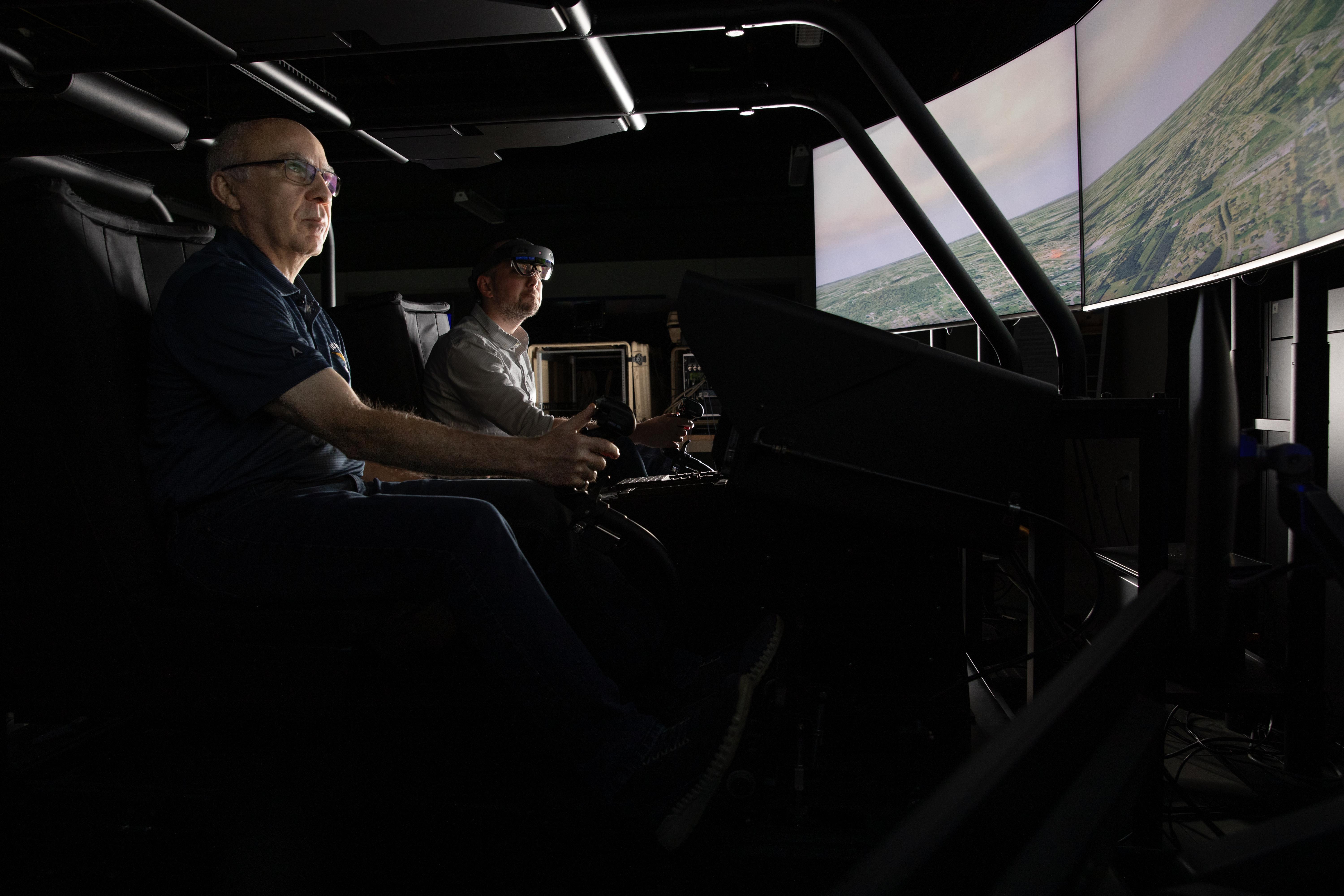 GTRI Principal Research Engineer Eric Grigorian (left) leads a flight simulator presentation at GTRI's Huntsville Research Center