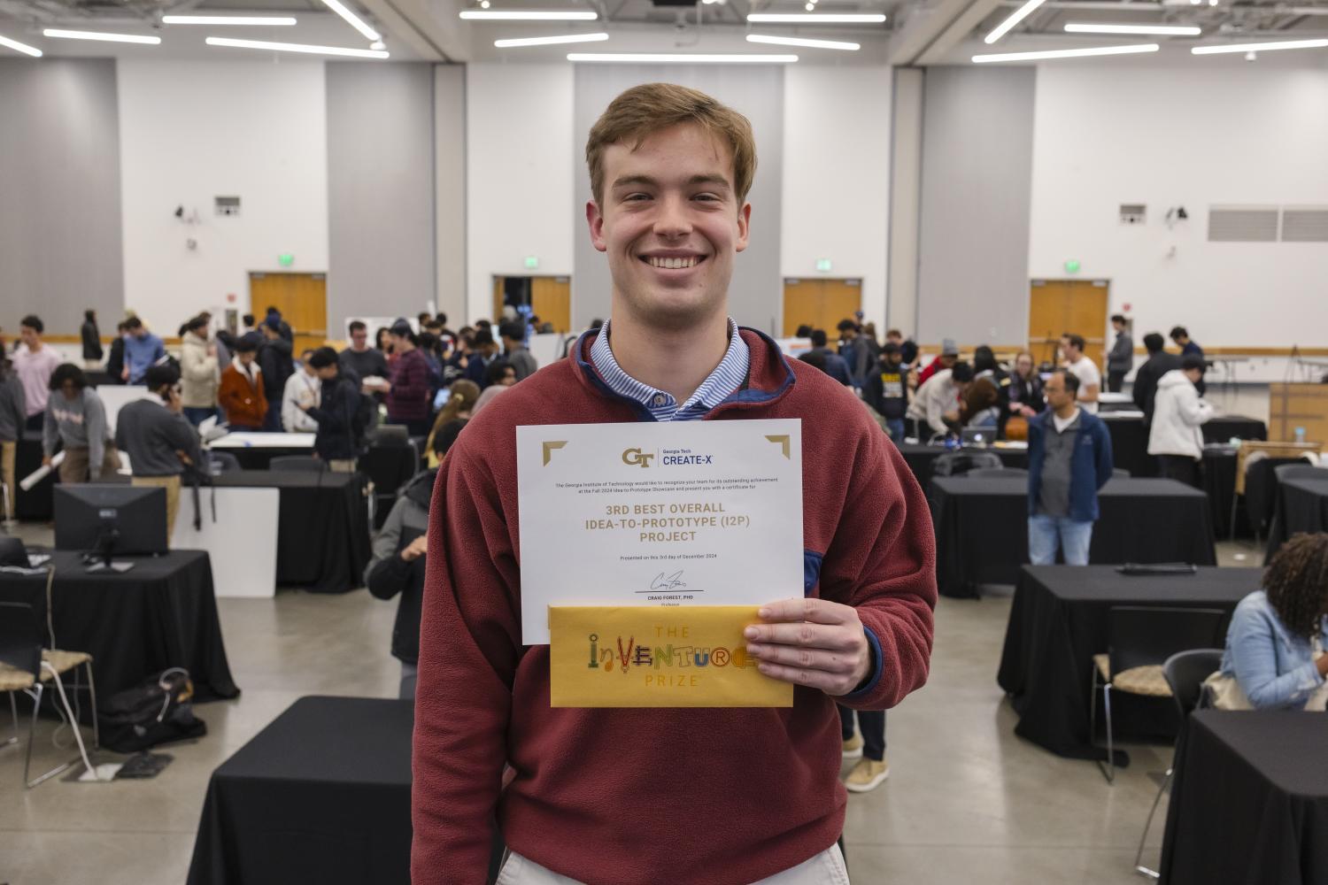 SuperStream Founder John Wright Stanly, a fourth-year computer science major, stands with his third-place certificate and InVenture Prize invitation at the Fall 2024 I2P Showcase.