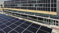 A view of the Carbon Neutral Energy Solutions Laboratory building highlighting two of its solar arrays, one on its southern facade, and the other covering an adjacent parking area.