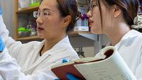 two female researchers in a Georgia Tech lab wearing white coats