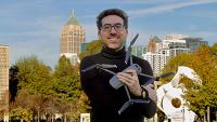 Tarek Rakha on the Georgia Tech campus holding a drone in his arms.