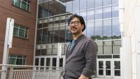 Eric Shen standing outside an academic building with many windows