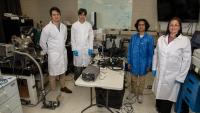 Four GTRI researchers pose for a photo in a lab space. 