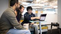 From left to right, Simar Kareer, Joanne Truong, and Naoki Yokoyam work together on developing a quadrupedal robot that can navigate over obstacles. (Photos by Kevin Beasley/College of Computing)