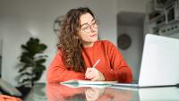 woman taking notes during class 