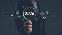 Businessman holding magnifying glass focusing on year 2026 with digital icons of innovation, AI, analytics, and global strategy. Concept of future planning, technology trends and vision. 