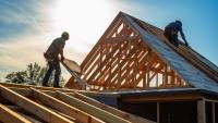 Carpenters build a roof on a residential house