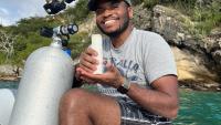 Man holds coral on boat
