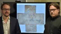 <p>Georgia Tech professor David Citrin (right) and adjunct professor Alexandre Locquet stand in front of an image of the 16th-century funerary cross used in their study. Credit: Nicolas Jacquet</p>