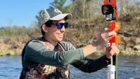 Eric Greenlee, a student from Georgia Tech, installs water-level sensors in lakes at Lac du Flambeau to help monitor wild rice beds. (Photo courtesy Naomi Blinick)