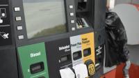 Picture of an empty gasoline pump with a bagged spout and paper signs taped to it.