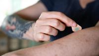 <p>A microneedle patch tattoo is pressed to the skin.</p>