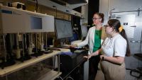 Two researchers work on a computer in a lab