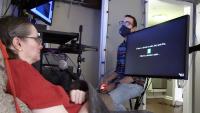 During a research session, a participant looks at a monitor and imagines saying the text cue displayed on screen. Text below the cue shows the brain-computer interface’s prediction of her imagined words.