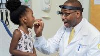 <p>Georgia CTSA investigator Charles E. Moore, MD, professor at the Emory University School of Medicine, examines a young patient.</p>
