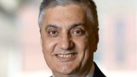 Headshot of Chaouki Abdallah wearing a navy suit jacket and gold-patterned tie with a white a shirt. Chaouki is smiling.