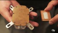 Two hands hold an electronic device that has the EMCOOL integrated liquid cooling technology as part of its enclosure.