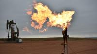 A flare burns natural gas at an oil well on Aug. 26, 2021, in Watford City, N.D. 