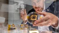 Jud Ready holds a sample of a perovskite solar cell, along with other samples similar to those launched to the International Space Station. (Photo: Branden Camp)