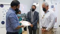 <p>Asif Khan (left) discusses his research with Georgia Tech President Angel Cabrera (right) during a 2021 visit to Khan's lab.</p>