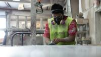 Man sanding a slab of fabricated stone.